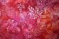 Preview: roter Batikstoff von Robert Kaufmann, Motiv: Blätter, Farben: rot-orange