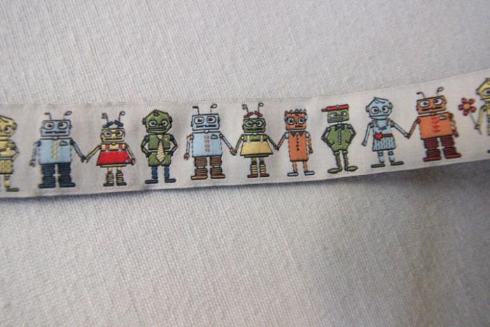 Webband, Robotor auf beigem Hintergrund, 25 mm, Farben: beige, hellblau, olive, rot